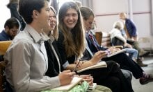 Youth plaintiffs sit on a bench laughing together.