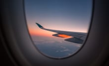 Wing of plane and sunset out window of airplane