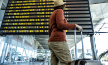 Woman In The Airport In Front Of The Flight Information Display