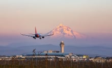 Southwest Airlines airplane flying near airport with mountain in background