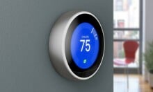 a google nest learning thermostat on a blue wall