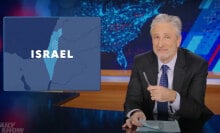 A man sits at a talk show desk while Israel is shown on a map in the top-left corner.