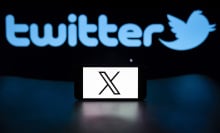 X logo on mobile device in front of the old Twitter logo