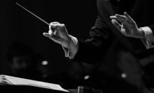 Hands of a conductor of a symphony orchestra close-up in black and white