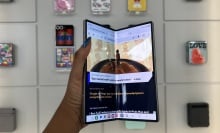 Hand holding Samsung Galaxy Z Fold 6 showcasing main display slightly closed