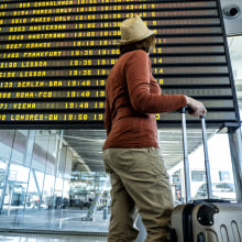 Woman In The Airport In Front Of The Flight Information Display