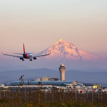 Southwest Airlines airplane flying near airport with mountain in background