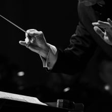 Hands of a conductor of a symphony orchestra close-up in black and white