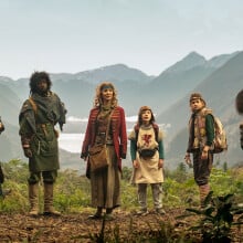 The cast of "Time Bandits" stand in a lush setting.