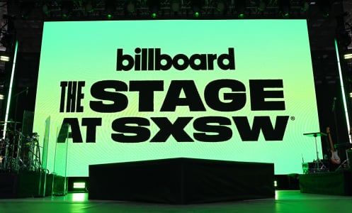 A glowing green screen on a stage that reads "Billboard. The stage at SXSW."