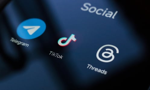 A close up of a phone screen showing the Telegram, TikTok, and Threads apps. 