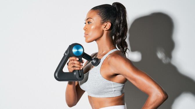 Person using Theragun Pro massage gun on shoulder