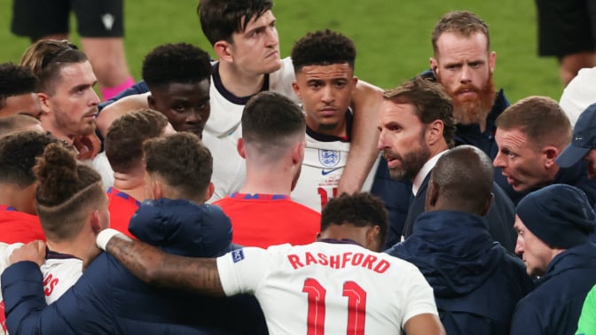 Gareth Southgate, head coach of England, talking to his players during a football game. 