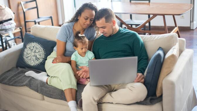 A family gathers around a computer.