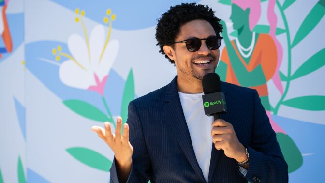 Trevor Noah holding a Spotify microphone.