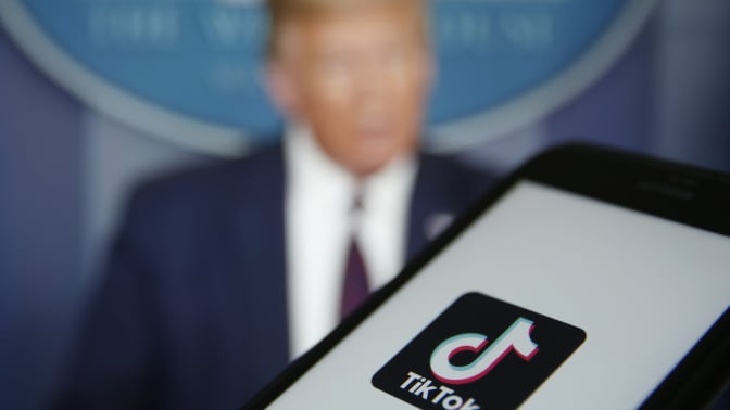 The TikTok logo is displayed in the app store in this arranged photograph in view of a video feed of U.S. President Donald Trump in London, U.K., on Monday, Aug. 3, 2020. TikTok has become a flash point among rising U.S.-China tensions in recent months as U.S. politicians raised concerns that parent company ByteDance Ltd. could be compelled to hand over American users data to Beijing or use the app to influence the 165 million Americans, and more than 2 billion users globally, who have downloaded it.