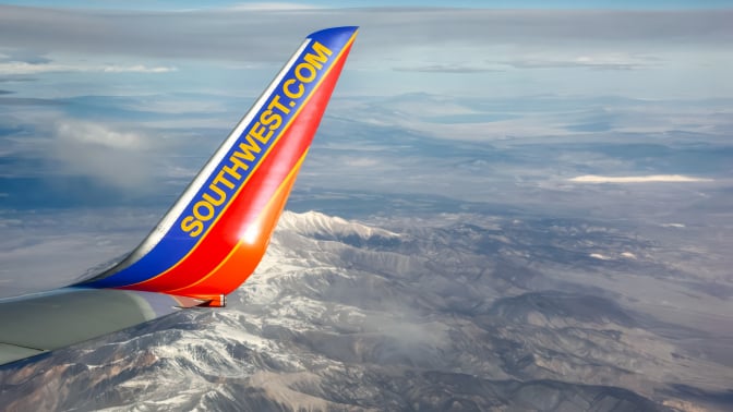 Southwest Airlines plane wing flying over snowcapped mountains