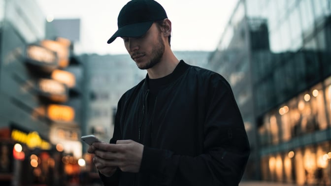 man in hat browsing their phone