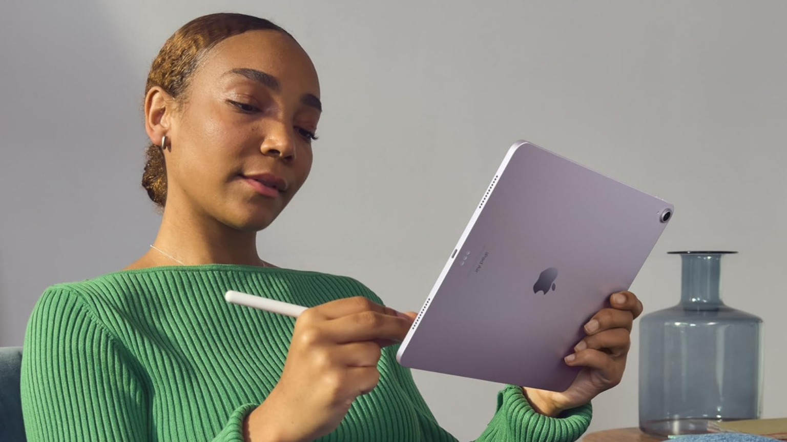 A person holding an iPad Air and Apple Pencil