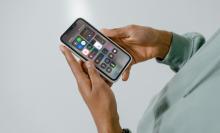 A mockup of an iPhone screen's Control Centre on an iPhone held by a person.