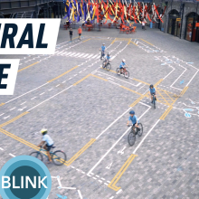 A top down view of children riding bicycles over the painted art installation "Natural Cycle".