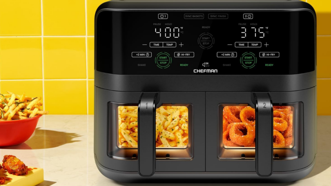 Chefman air fryer with fries and onion rings in baskets and other fried appetizers on counter beside it